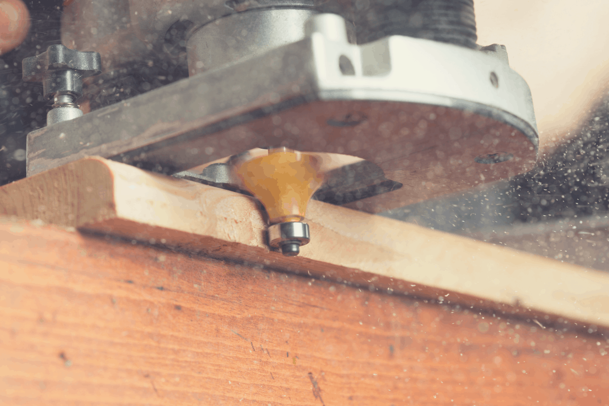 A close up image of a edge forming router bit cutting the edge of a piece of wood.